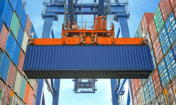Shore crane loading containers in freight ship