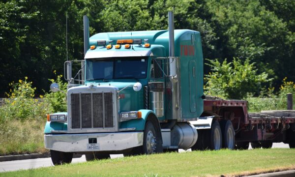 Teal truck with flatbed on road
